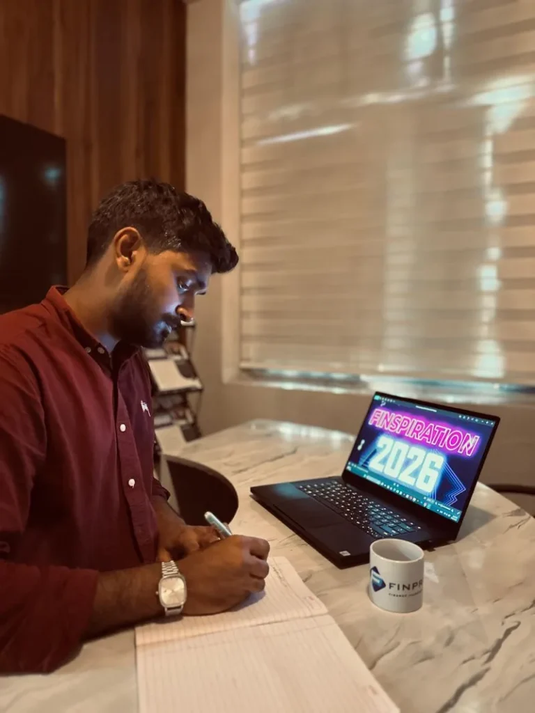 Muhammed Yasin, best freelance digital marketer in kannur, writing notes beside a laptop at his desk.